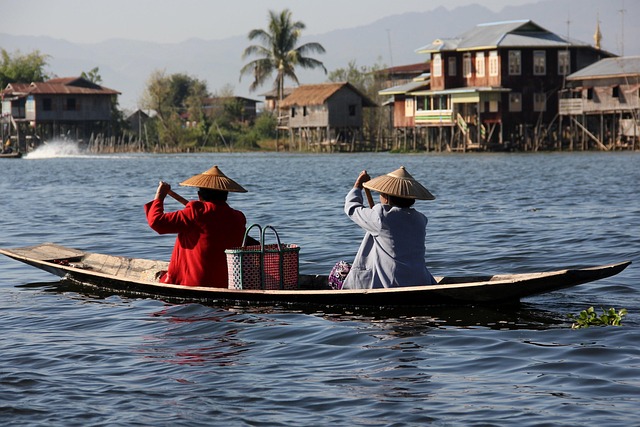 Mirror-light dawn over Inle with boats gliding through garden water