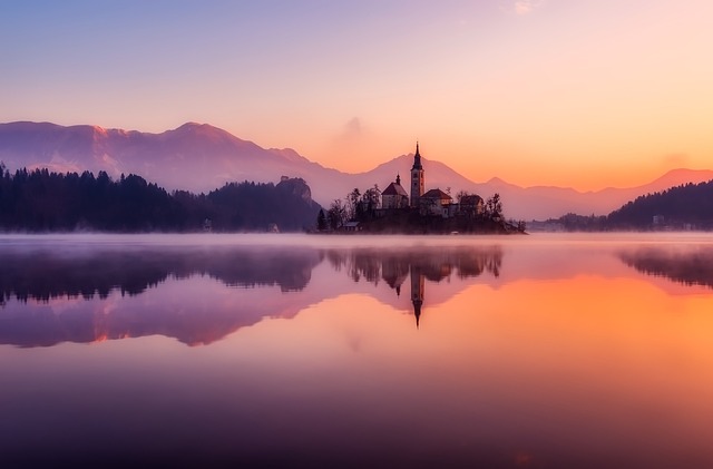 Mirror-water calm in Slovenia where the mountains arrive in perfect reflection